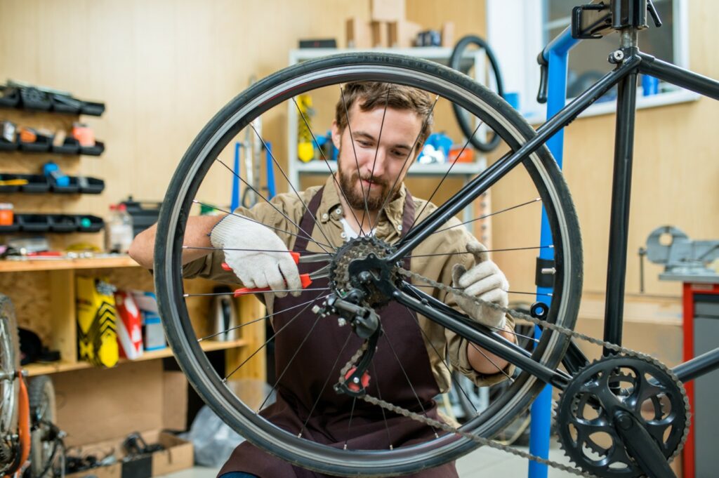 mécanicien retirant une roue de vélo arrière